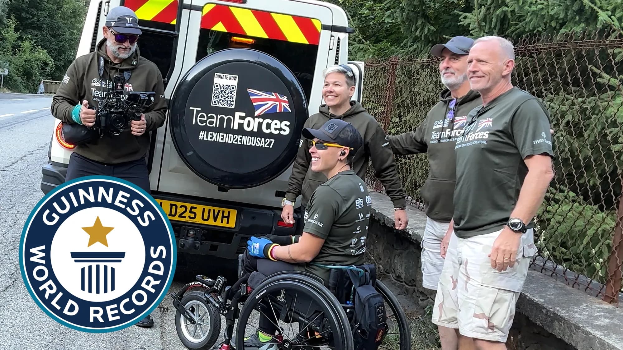 Lexi in her wheelchair with the Team Forces crew beside their support vehicle, with the Guinness World Records logo